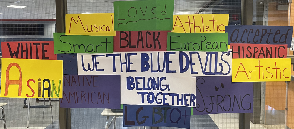 Window of posters, We the Blue Devils Belong Together: White, Asian, Musical, Smart, Black, Loved, Athletic, European, Accepted, Hispanic, Artistic, LGBTO, Strong