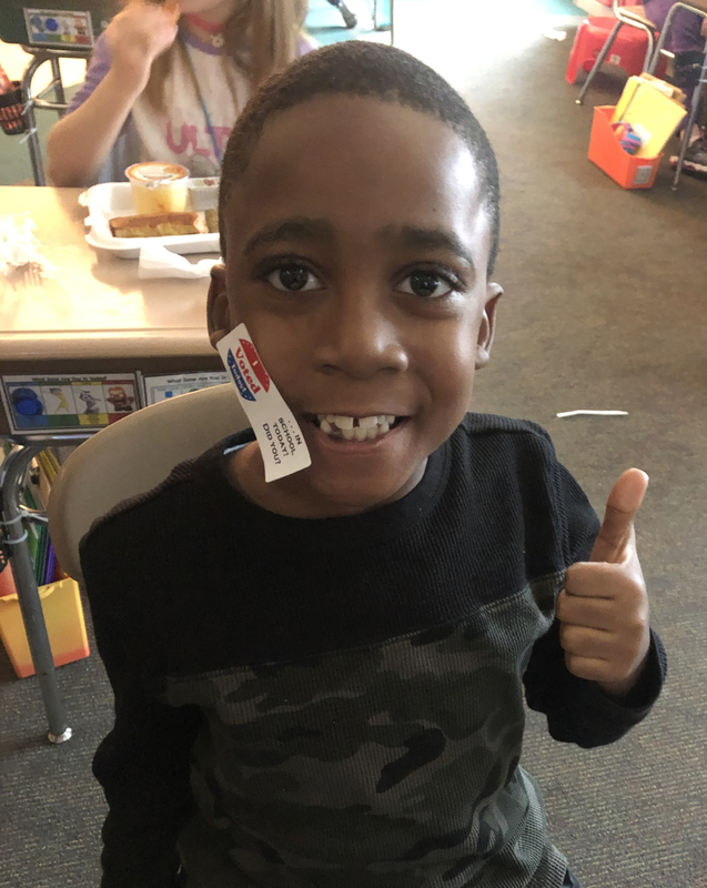 Boy gives thumbs up to voting.